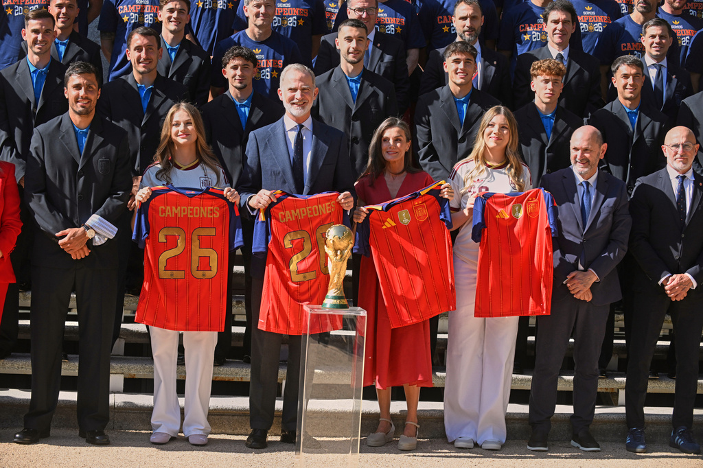 Spain's King Felipe VI and Queen Letizia, accompanied by Princess Leonor, left, and Infanta Sofia, right, pose with players from Spain's national soccer team at Zarzuela Palace in Madrid on Monday, July 20, 2026, after the team was crowned World Cup champion. (Jose Oliva/Europa Press via AP)