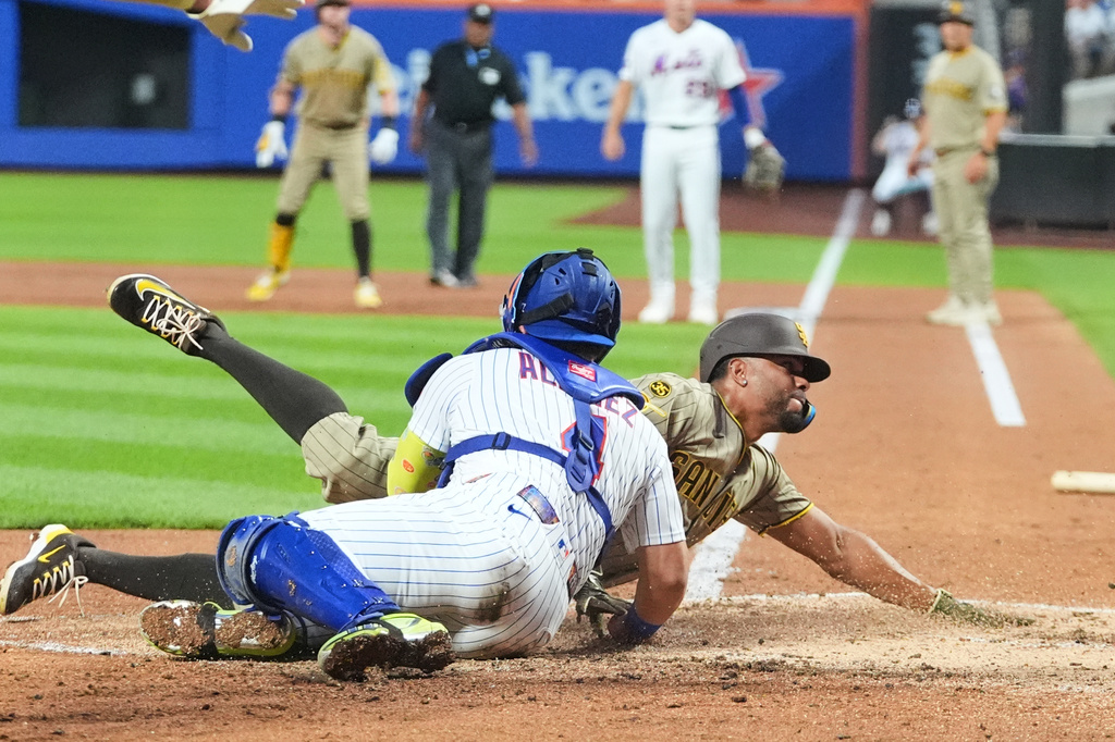 New York Mets catcher Francisco Alvarez (4) tags out San Diego Padres' Xander Bogaerts at home plate during the second inning of a baseball game Monday, Aug. 17, 2026, in New York. (AP Photo/Frank Franklin II)