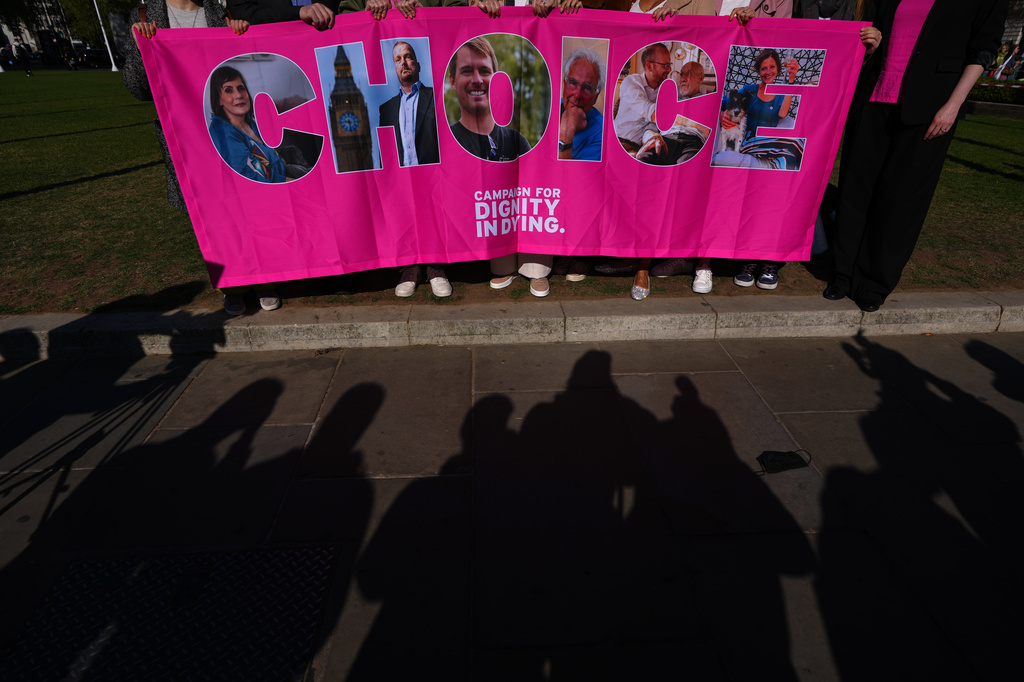 Campaigners hold a banner outside parliament in London as a proposed law to legalise assisted dying in England and Wales will run out of time on Friday, more than a year after MPs first voted in favour of it, Friday, April 24, 2026. (AP Photo/Kirsty Wigglesworth)