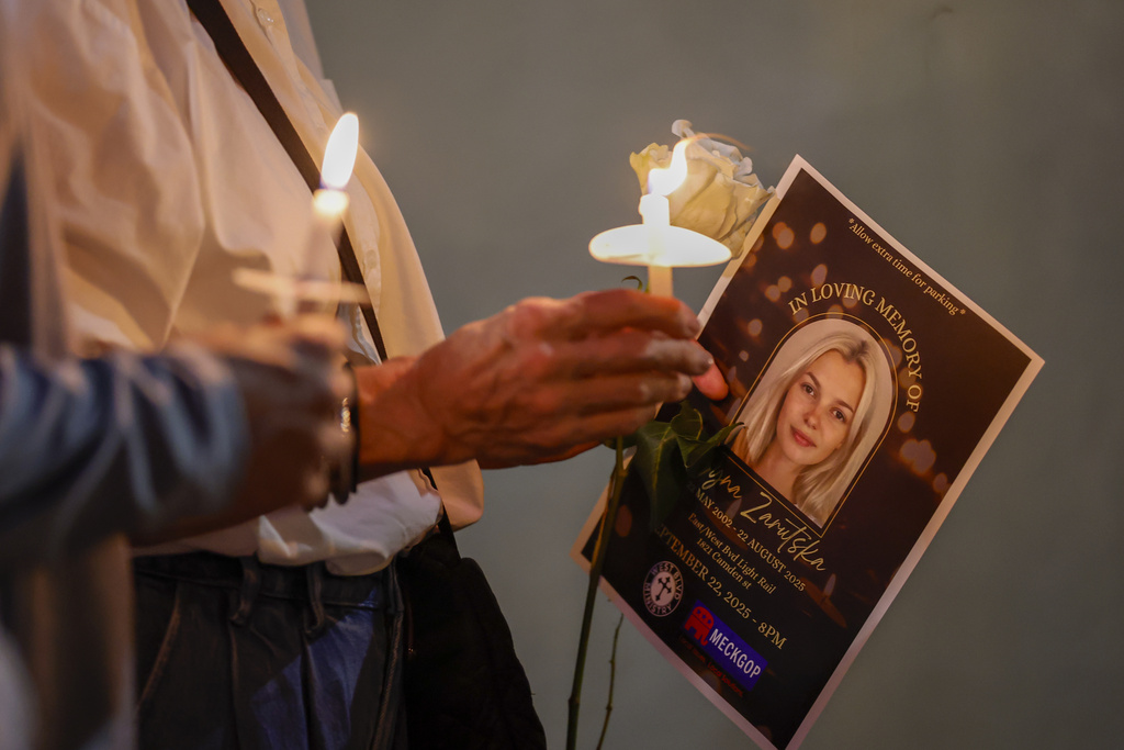 Community members hold candles as they gather for a vigil honoring the life of Iryna Zarutska, who was fatally stabbed on a commuter train last month, Monday, Sept. 22, 2025, in Charlotte, N.C. (AP Photo/Nell Redmond)