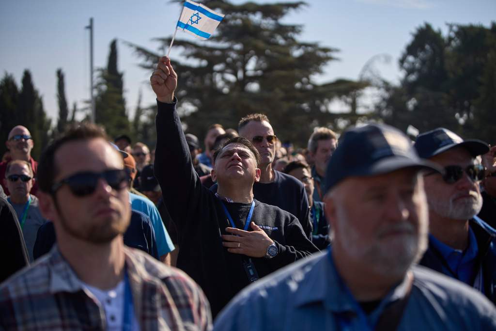 FILE - People pray as they visit at Mount Herzl military cemetery in Jerusalem, Dec. 4, 2025. (AP Photo/Ohad Zwigenberg, File)