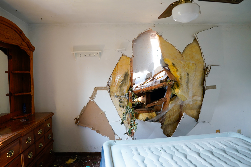 Debris is seen through the drywall of a bedroom after a tornado hit the day before in Menasha, Wis., Tuesday, July 28, 2026. (AP Photo/Kayla Wolf)
