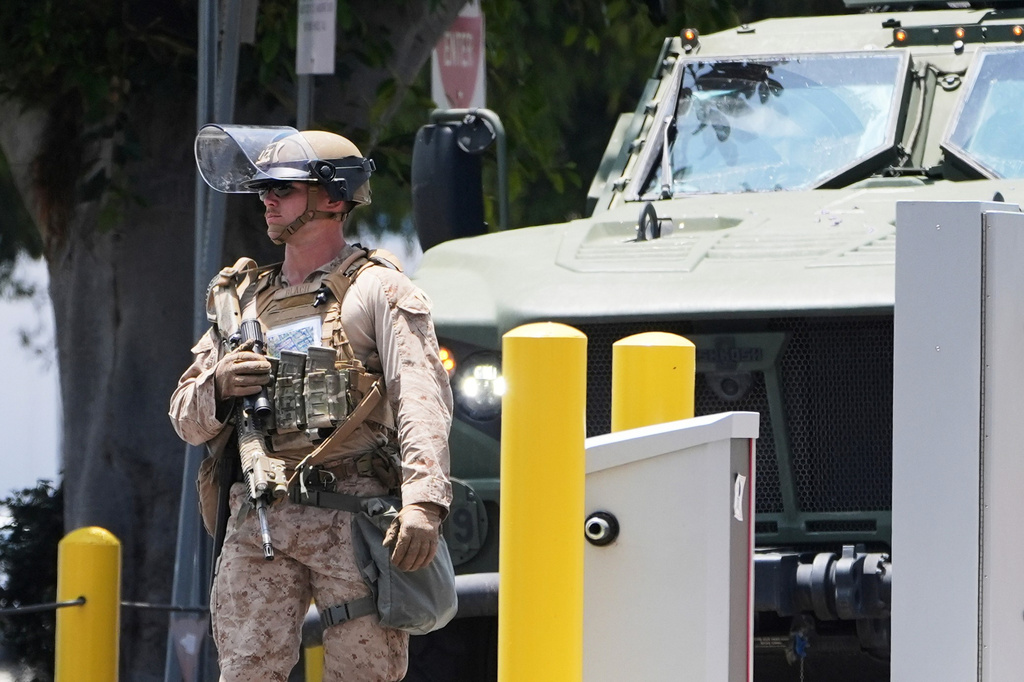 FILE - A U.S. Marine patrols outside of a federal building, June 13, 2025, in Los Angeles (AP Photo/Damian Dovarganes, File)