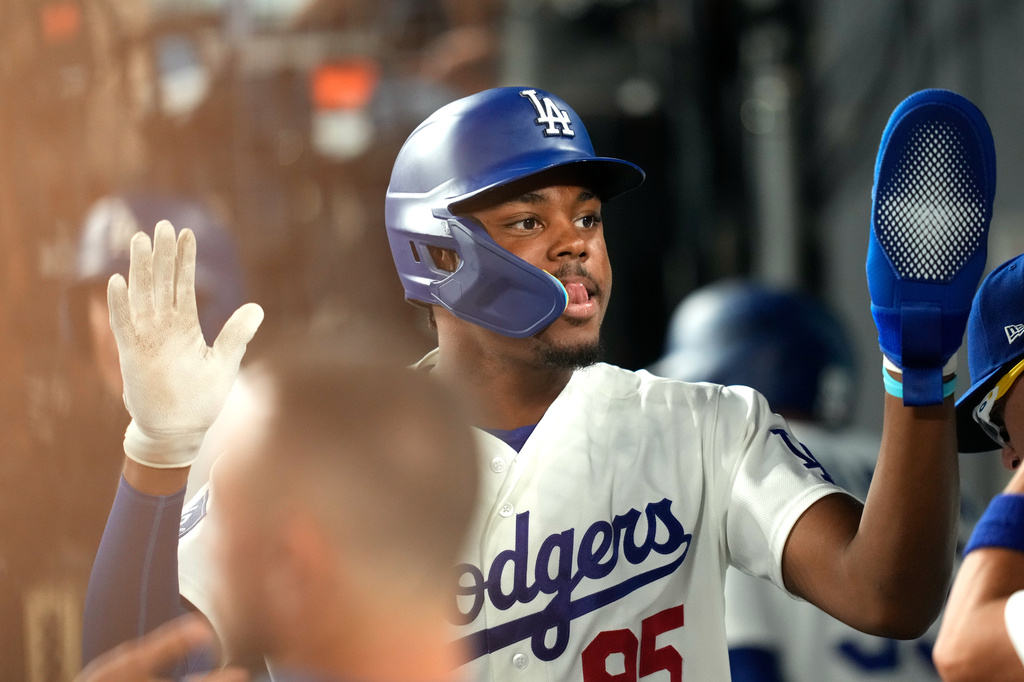 Los Angeles Dodgers' Josue De Paula is congratulated by teammates in the dugout after scoring on a walk by Mookie Betts during the second inning of a baseball game against the San Diego Padres, Tuesday, Sept. 22, 2026, in Los Angeles. (AP Photo/Mark J. Terrill)