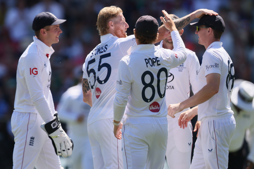 England's Ben Stokes, centre, celebrates with teammates after dismissing Australia's Alex Carey during play on day four of the third Ashes cricket test between England and Australia in Adelaide, Australia, Saturday, Dec. 20, 2025. (AP Photo/James Elsby)
