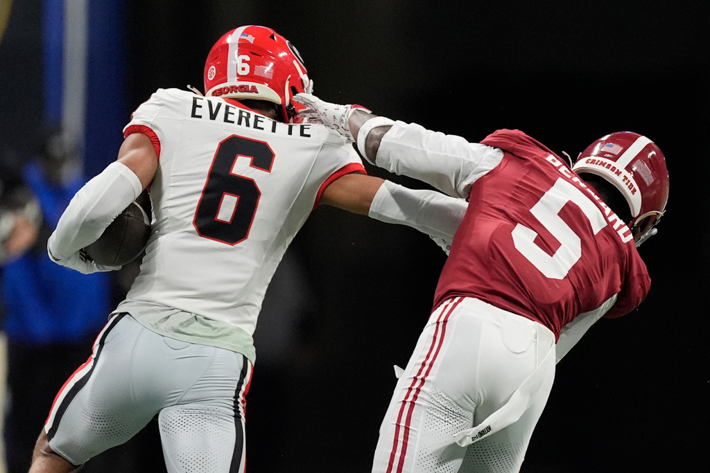 Georgia defensive back Daylen Everette (6) runs an intercepted ball against Alabama wide receiver Germie Bernard (5) during the first half of a Southeastern Conference championship NCAA college football game, Saturday, Dec. 6, 2025, in Atlanta. (AP Photo/Mike Stewart)