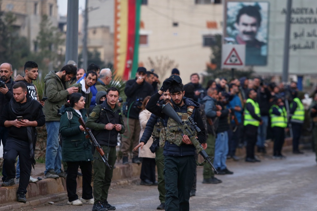 Kurdish-led Syrian Democratic Forces (SDF) combatants secure the area for the arrival of Syria's Interior Ministry security forces, deployed under an agreement aimed at stabilizing a ceasefire, in Qamishli, eastern Syria, Tuesday, Feb. 3, 2026. (AP Photo/Baderkhan Ahmad)