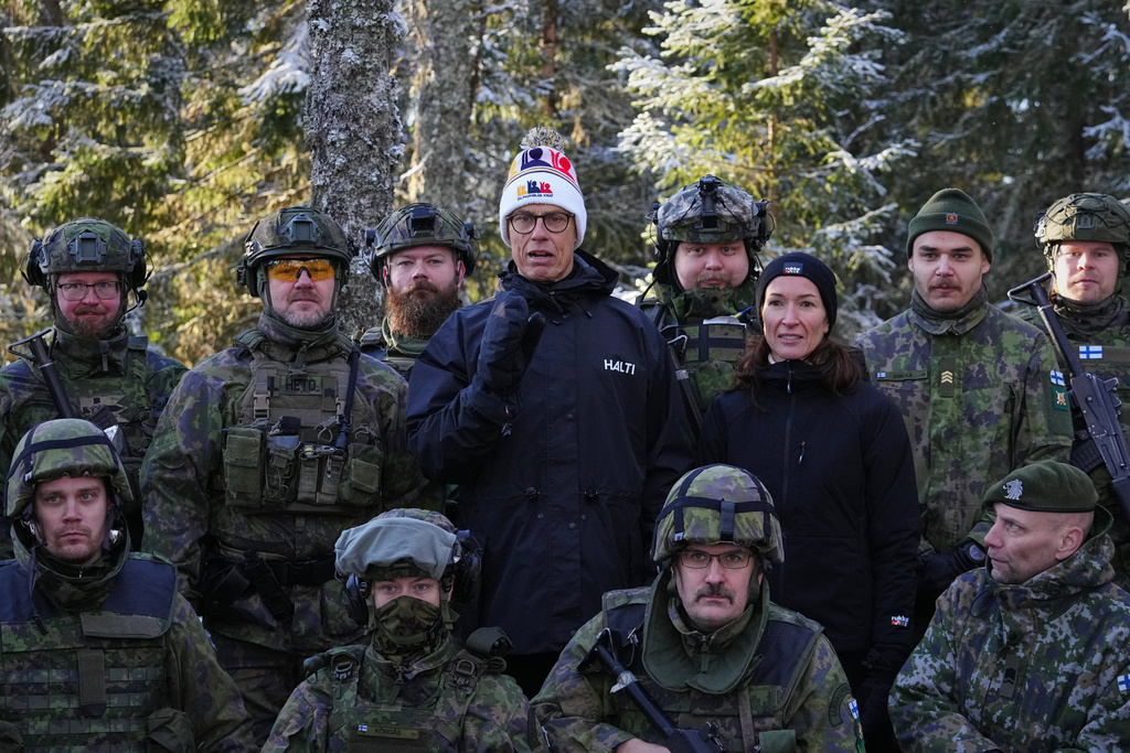 Finland's President Alexander Stubb, center, and his wife Suzanne Innes-Stubb pose for a photo with volunteers during a combat rescue exercises organized by the National Defence Training Association of Finland, in Halvala, Finland, Saturday, Nov. 15, 2025. (AP Photo/Sergei Grits)