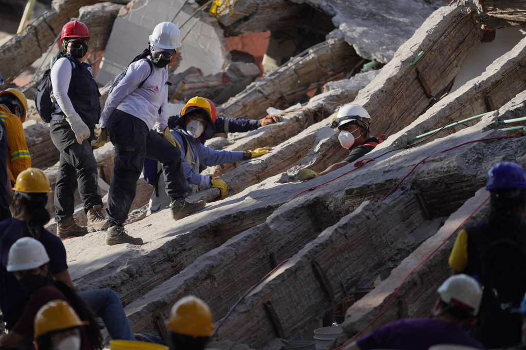 Rescuers search through the rubble three days after an earthquake struck Cali, Colombia, Thursday, Aug. 13, 2026. (AP Photo/Ivan Valencia)