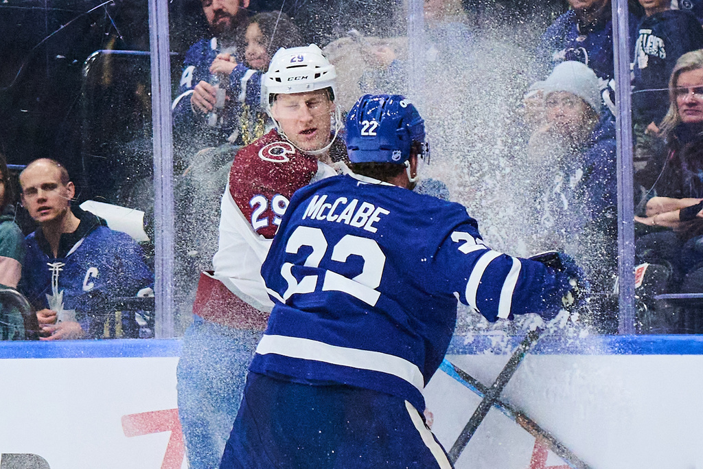 Colorado Avalanche's Nathan MacKinnon (29) and Toronto Maple Leafs' Jake McCabe (22) collide during first period NHL hockey action in Toronto, on Sunday, Jan. 25, 2026. (Sammy Kogan/The Canadian Press via AP)