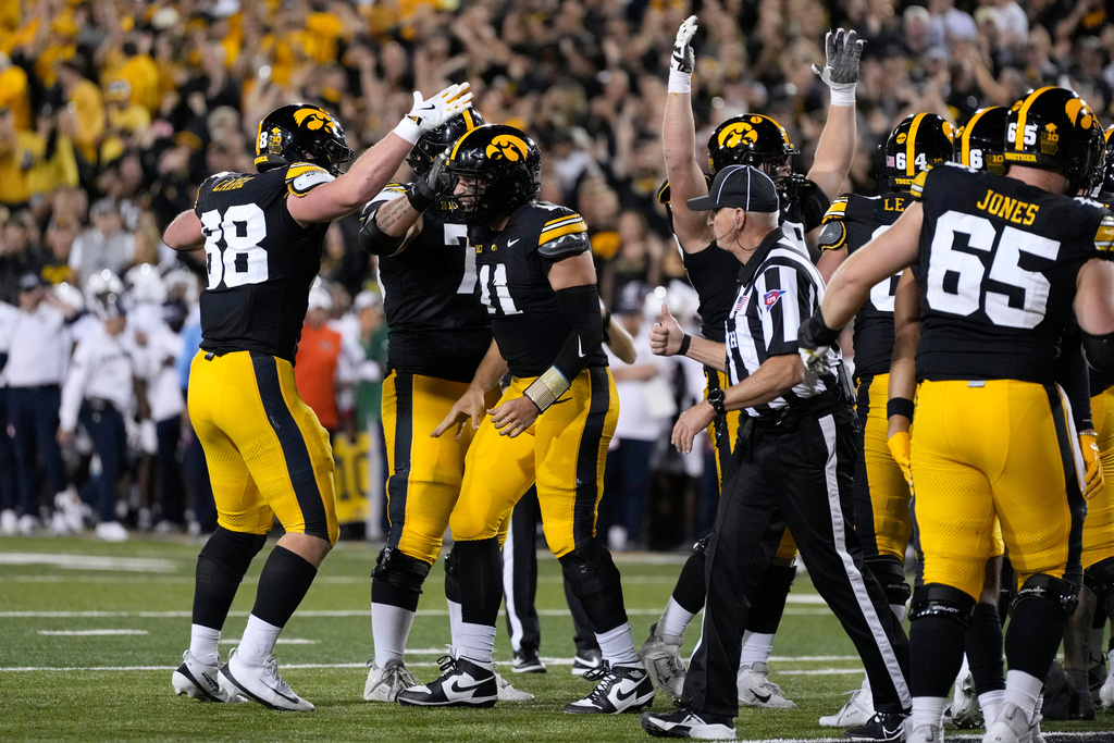 Iowa quarterback Mark Gronowski (11) celebrates with teammates after scoring a touchdown during the first half of an NCAA college football game against Penn State, Saturday, Oct. 18, 2025, in Iowa City, Iowa. (AP Photo/Charlie Neibergall)