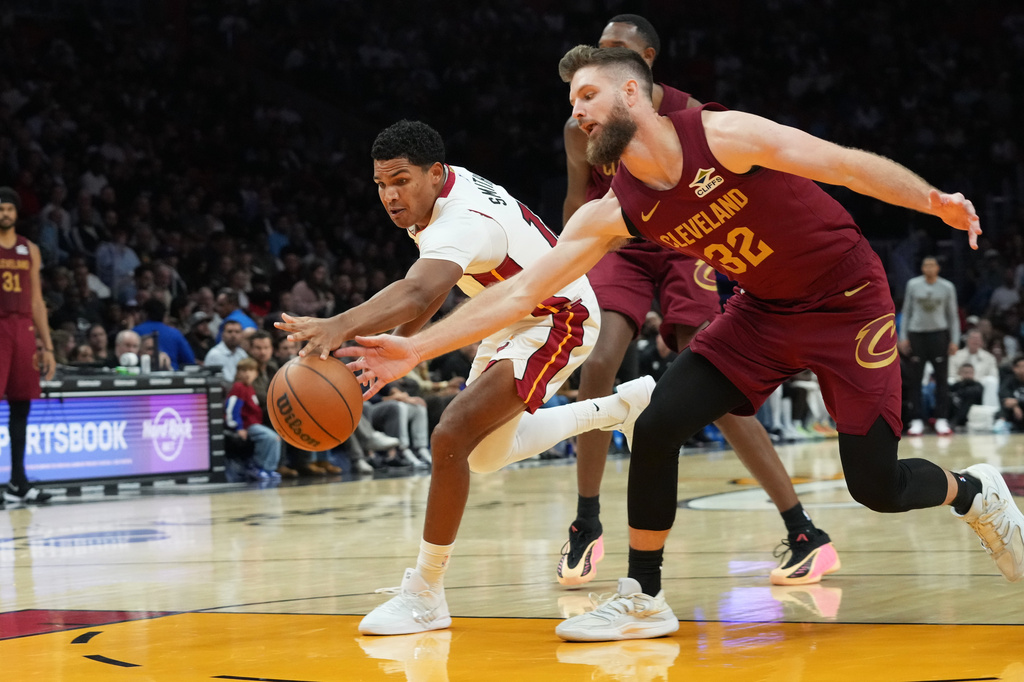 Miami Heat guard Dru Smith (12) and Cleveland Cavaliers forward Dean Wade (32) go after a loose ball during the first half of an NBA basketball game Monday, Nov. 10, 2025, in Miami. (AP Photo/Marta Lavandier)