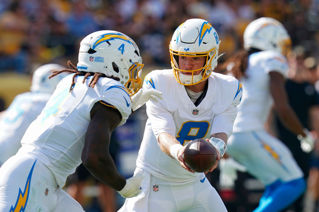 FILE - Los Angeles Chargers quarterback Taylor Heinicke (8) hands the ball off to running back Gus Edwards, left, during the second half of an NFL football game against the Pittsburgh Steelers, Sept. 22, 2024, in Pittsburgh. (AP Photo/Matt Freed, File)