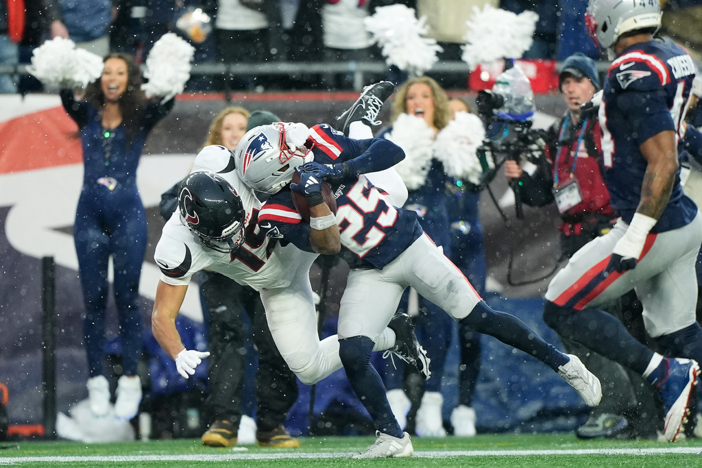 New England Patriots cornerback Marcus Jones (25) returns an interception for a touchdown against Houston Texans wide receiver Xavier Hutchinson (19) during the first half of an NFL divisional playoff football game, Sunday, Jan. 18, 2026, in Foxborough, Mass. (AP Photo/Robert F. Bukaty)