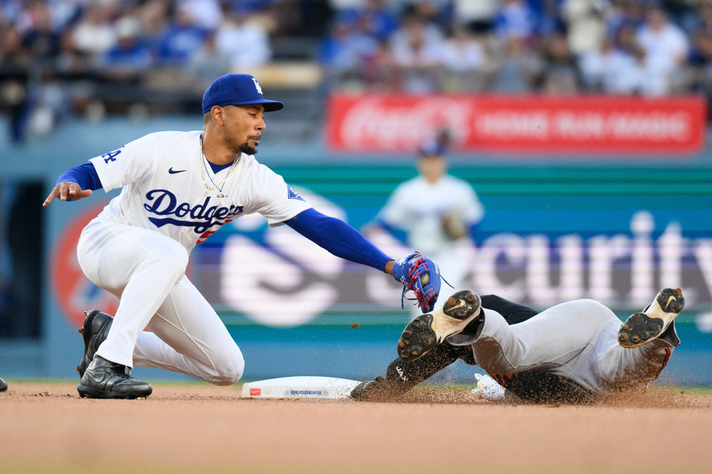 Los Angeles Dodgers shortstop Mookie Betts, left, tags out Baltimore Orioles' Taylor Ward, right, during the first inning of a baseball game in Los Angeles, Friday, June 19, 2026. (AP Photo/Kyusung Gong)