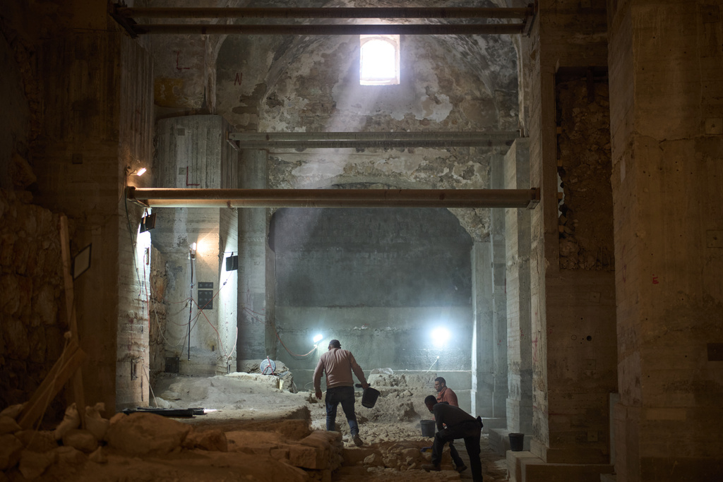 Workers from the Israel Antiquities Authority clean a section of an excavation site where, according to the institution, a city wall from the Hasmonean period, dating to the late 2nd century BCE, was uncovered under the Tower of David Citadel Museum, in the Old City of Jerusalem, Monday, Dec. 8, 2025. (AP Photo/Leo Correa)