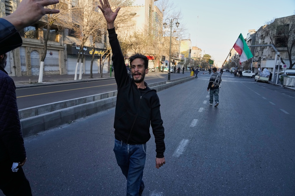 A man shouts slogans as he walks ahead of a group of government supporters marching in support of the late Iranian Supreme Leader Ayatollah Ali Khamenei in Tehran, Iran, Sunday, March 1, 2026, in the aftermath of his confirmed death in U.S. and Israeli strikes. (AP Photo/Vahid Salemi)