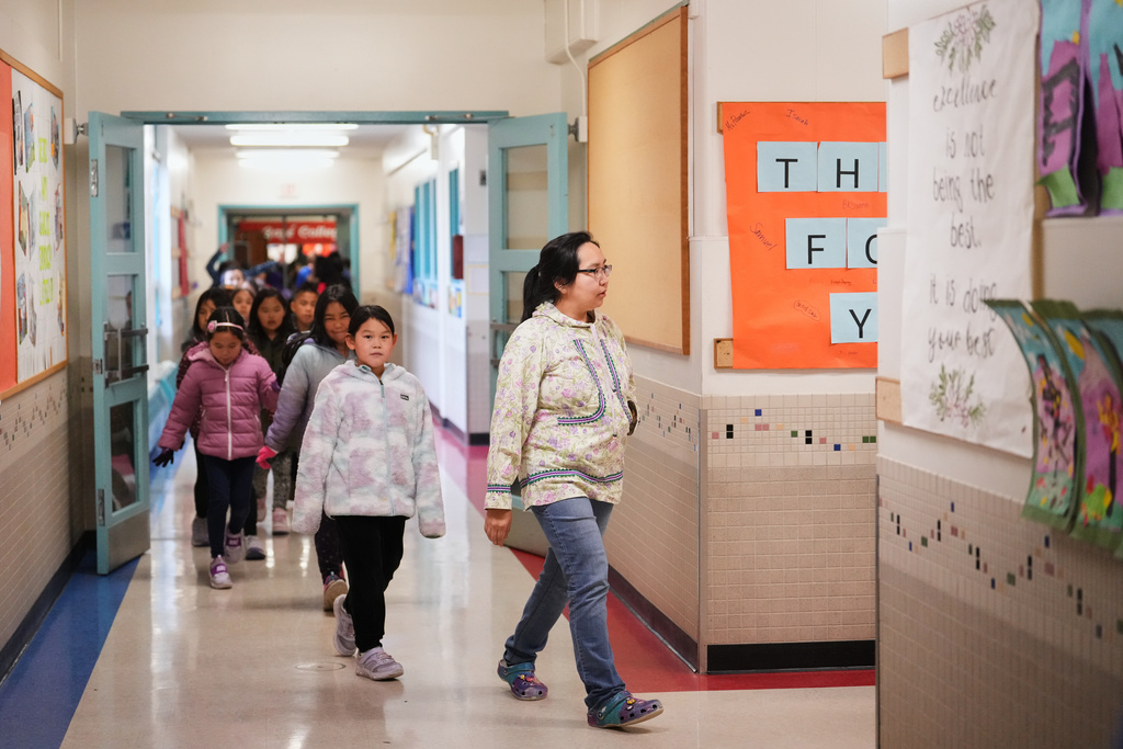 Renee Avugiak, originally from Chefornak, Alaska, near the villages of Kipnuk and Kwigillingok that were heavily damaged by ex-Typhoon Halong, leads her class through the hallways at College Gate Elementary, where students spend half their time learning in Yup'ik language immersion, Thursday, Oct. 30, 2025, in Anchorage, Alaska. (AP Photo/Lindsey Wasson)
