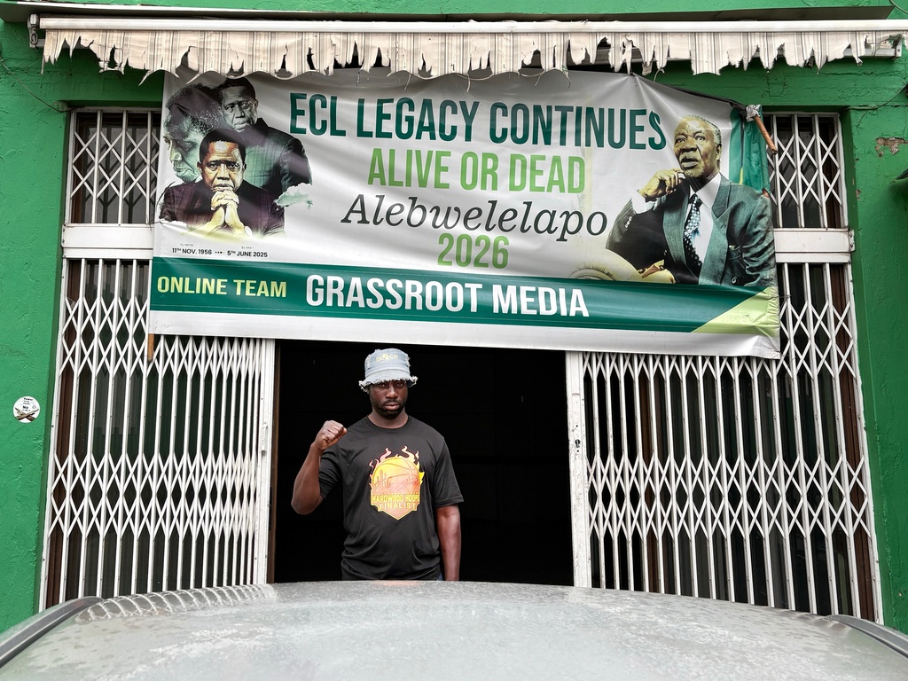 Richard Lungu, a supporter of former Zambian President Edgar Lungu, makes a power fist at the entrance to the headquarters of the opposition Patriotic Front party in Lusaka, Zambia, Thursday, Feb.12, 2026. (AP Photo/Rodney Muhumuza)