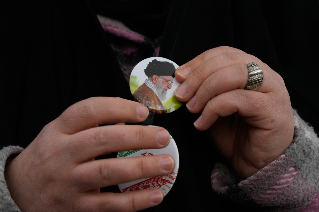A woman wears a badge with a portrait of the late Iranian Supreme Leader Ayatollah Ali Khamenei, who was killed in the U.S. and Israel strikes on Feb. 28, during a campaign in support of the government at the Enqelab-e-Eslami, or Islamic Revolution, Square in downtown Tehran, Iran, Monday, April 13, 2026. (AP Photo/Vahid Salemi)