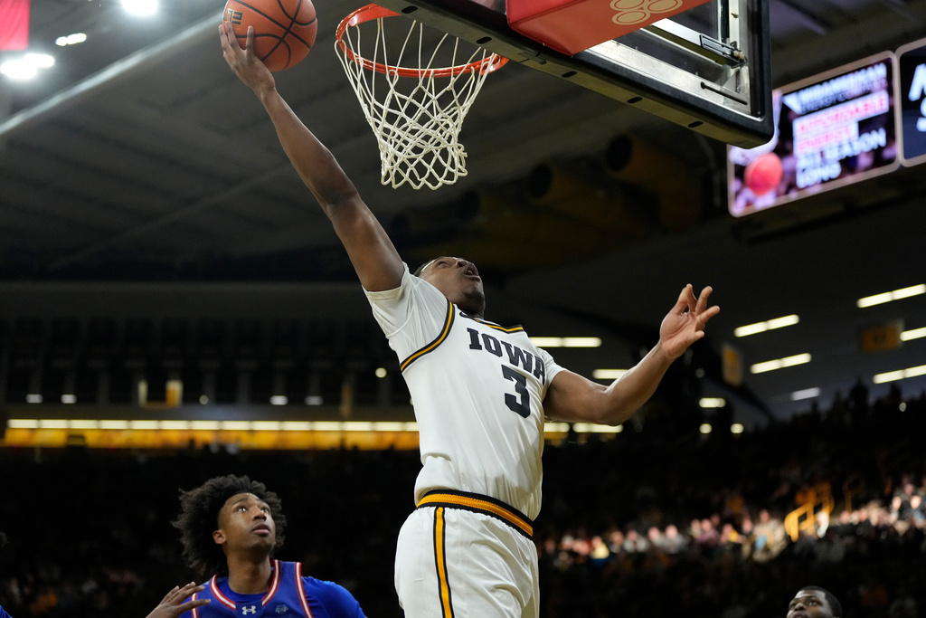 Iowa forward Cam Manyawu (3) drives to the basket over UMass-Lowell forward Austin Green, left, during the first half of an NCAA college basketball game, Monday, Dec. 29, 2025, in Iowa City, Iowa. (AP Photo/Charlie Neibergall)