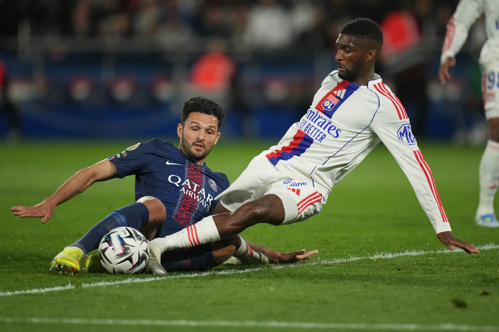 PSG's Goncalo Ramos, left, and Lyon's Clinton Mata challenge for the ball during the French League One soccer match between Paris Saint-Germain and Olympique Lyon in Paris, France, Sunday, April 19, 2026. (AP Photo/Christophe Ena)