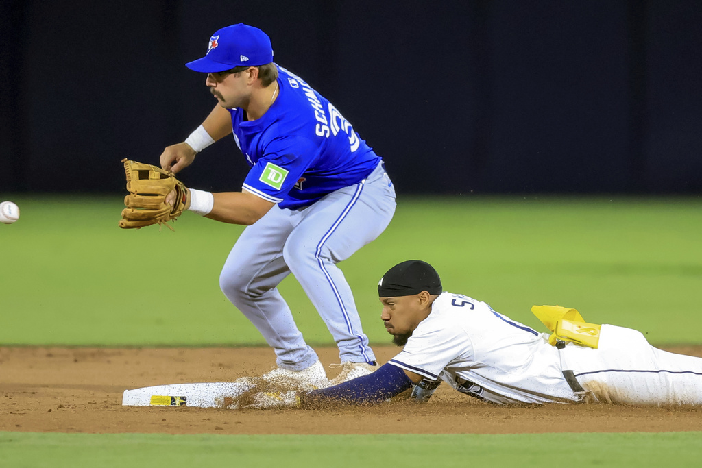 Tampa Bay Rays' Chandler Simpson slides in safely with a double ahead of a throw field by Toronto Blue Jays' Davis Schneider during the first inning of a baseball game Wednesday, Sept. 17, 2025, in Tampa, Fla. (AP Photo/Mike Carlson)