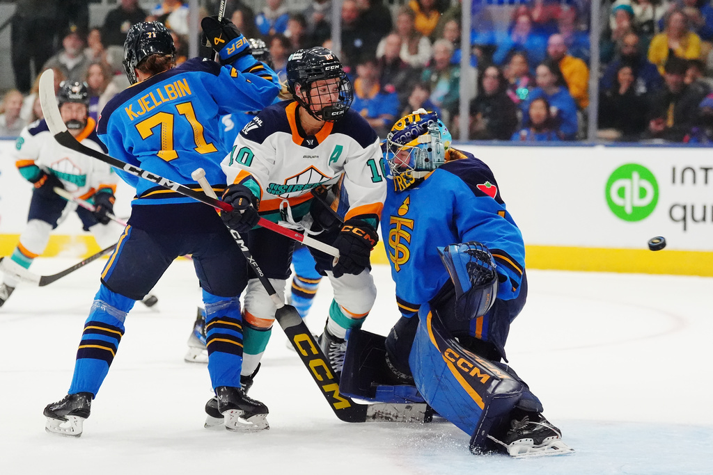 New York Sirens' Sarah Fillier (10) runs into Toronto Sceptres goaltender Raygan Kirk (1) as the puck enters the net and Sceptres' Anna Kjellbin (71) defends during the first period of an PWHL hockey game in Toronto on Tuesday, April 21, 2026. (Frank Gunn/The Canadian Press via AP)
