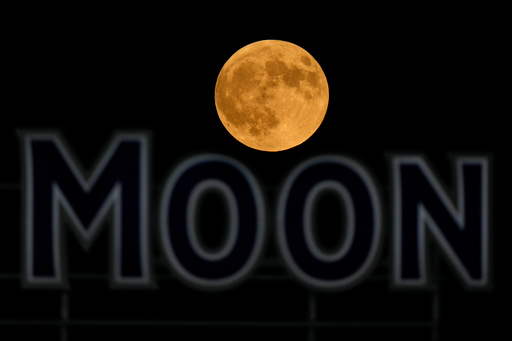 FILE - The full moon rises in the over a beer sign in the outfield at Kauffman Stadium during a baseball game between the Kansas City Royals and the Detroit Tigers, Tuesday, Sept. 17, 2024, in Kansas City, Mo. (AP Photo/Charlie Riedel, File) FILE - The full moon rises in the over a beer sign in the outfield at Kauffman Stadium during a baseball game between the Kansas City Royals and the Detroit Tigers, Tuesday, Sept. 17, 2024, in Kansas City, Mo. (AP Photo/Charlie Riedel, File)