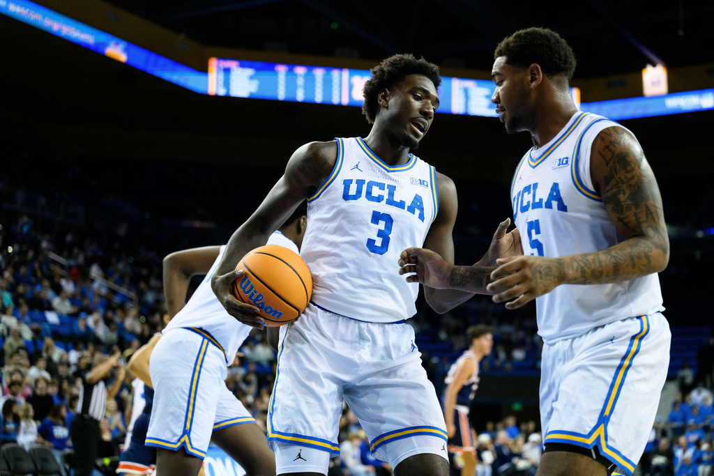 UCLA forward Eric Dailey Jr. (3) talks with UCLA guard Brandon Williams, right, during the first half of an NCAA college basketball game against Pepperdine Friday, Nov. 7, 2025, in Los Angeles. (AP Photo/William Liang)