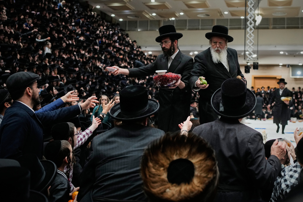 Ultra-Orthodox Jews from the Belz Hasidic dynasty pass plates of fruit during celebrations marking the Jewish holiday of Tu Bishvat, the "New Year of the Trees," in Jerusalem Monday, Feb. 2, 2026. (AP Photo/Ohad Zwigenberg)