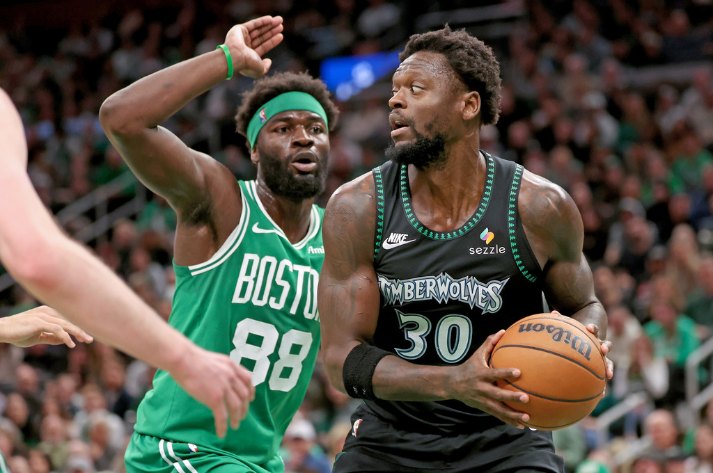 Minnesota Timberwolves forward Julius Randle (30) defends the ball from Boston Celtics center Neemias Queta (88) during the first half of an NBA basketball game, Sunday, March 22, 2026, in Boston. (AP Photo/Mark Stockwell)