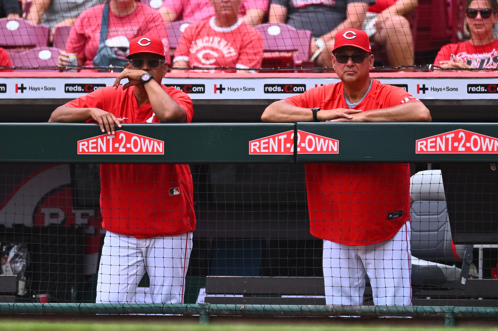 Cincinnati Reds bench coach/field coordinator Freddie Benavides, left, and manager Terry Francona, right, watch from the dugout railing during the third inning of a baseball game against the New York Mets in Cincinnati, Wednesday, June 17, 2026. (AP Photo/Ben Jackson)