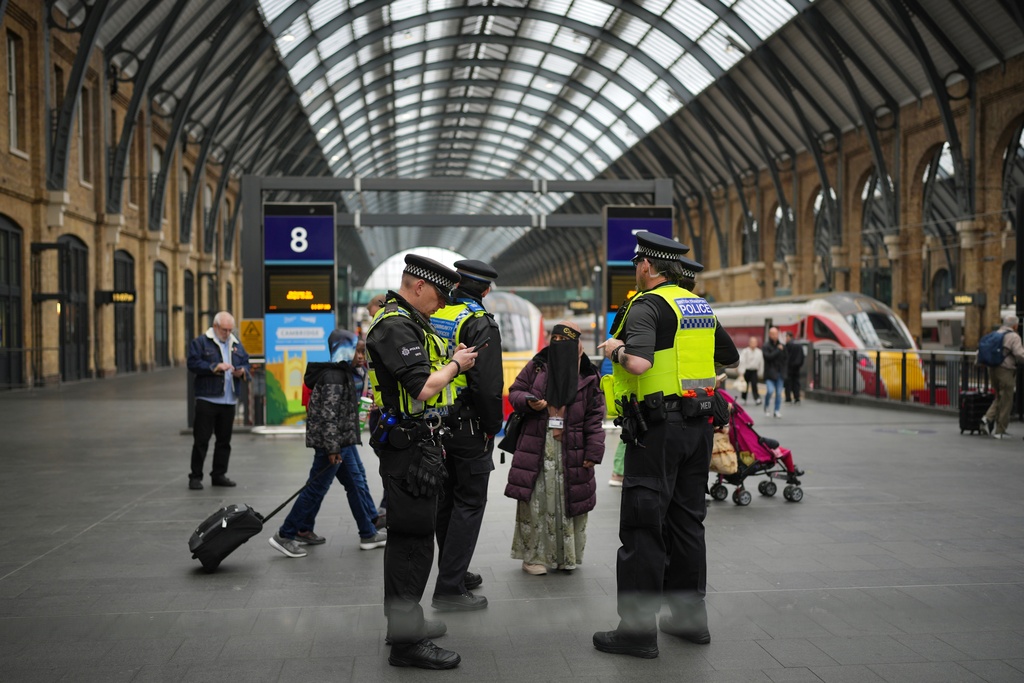 Police officers patrol King's Cross train station, in London, Monday, Nov. 3, 2025. (AP Photo/Kin Cheung)