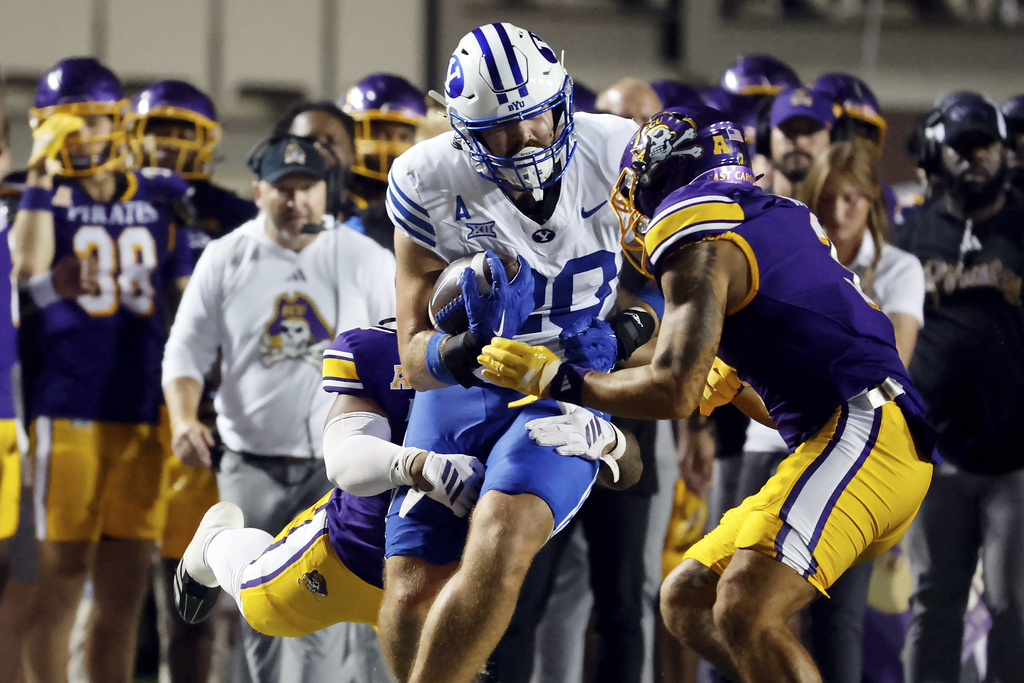 BYU tight end Carsen Ryan, front left, prepares to be hit by East Carolina's Teagan Wilk, front right, was called for targeting and ejected during the first half of an NCAA college football game in Greenville, N.C., Saturday, Sept. 20, 2025. (AP Photo/Karl DeBlaker)