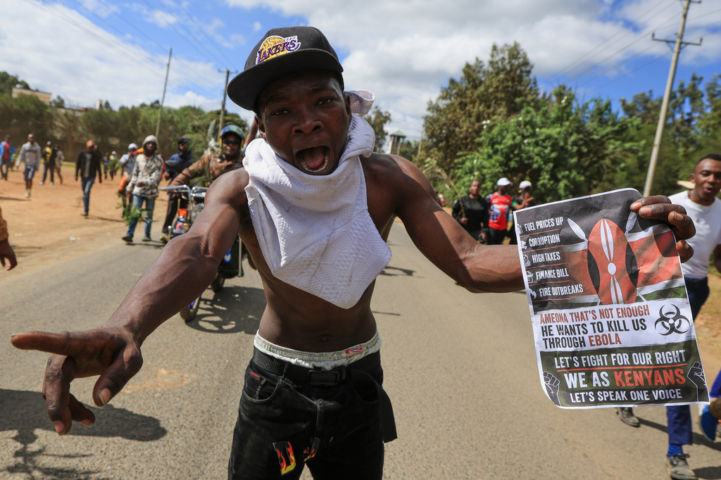 A protester holds up a sign during a demonstration against a proposed Ebola quarantine center to be established by the United States at Laikipia Air Base, in Nanyuki, Kenya, Monday, June 1, 2026. (AP Photo/Andrew Kasuku)