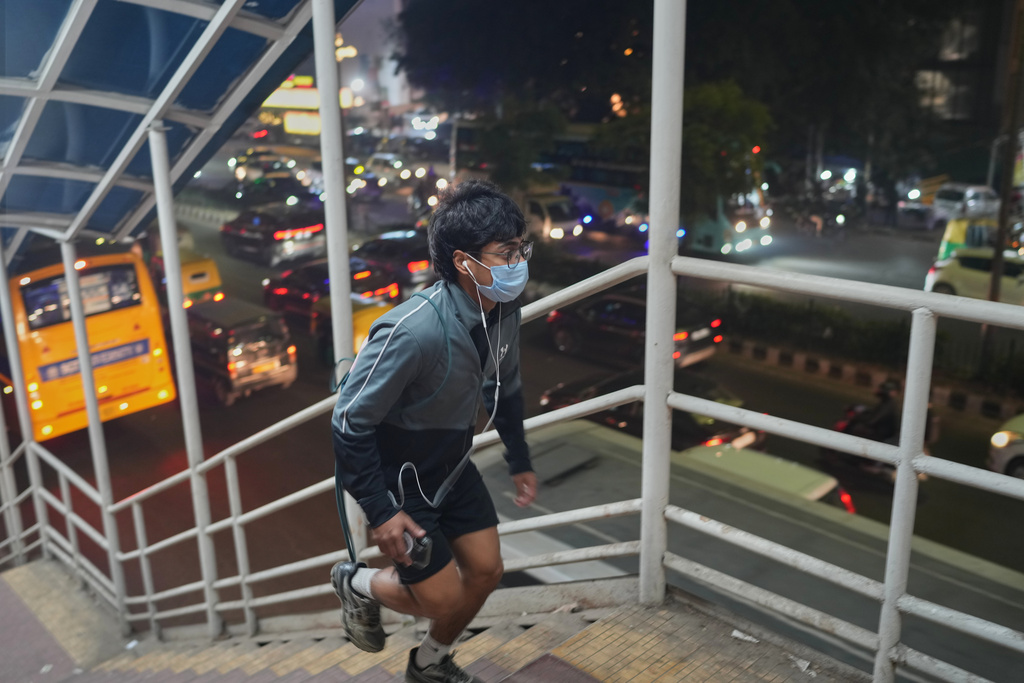 A person crosses an overbridge in New Delhi, India, Tuesday, Nov. 18, 2025. (AP Photo/Manish Swarup)