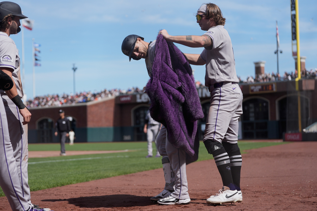 Colorado Rockies' Zac Veen, right, puts a coat on Brett Sullivan after Sullivan hit a three-run home run during the seventh inning of a baseball game against the San Francisco Giants, Sunday, Aug. 16, 2026, in San Francisco. (AP Photo/Jeff Chiu)