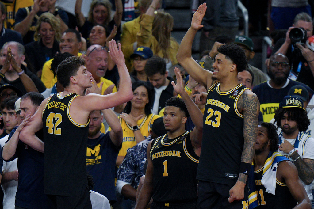 Michigan forward Yaxel Lendeborg (23) high fives forward Will Tschetter (42) during the second half of an NCAA college basketball tournament semifinal game against Arizona at the Final Four, Saturday, April 4, 2026, in Indianapolis. (AP Photo/AJ Mast)