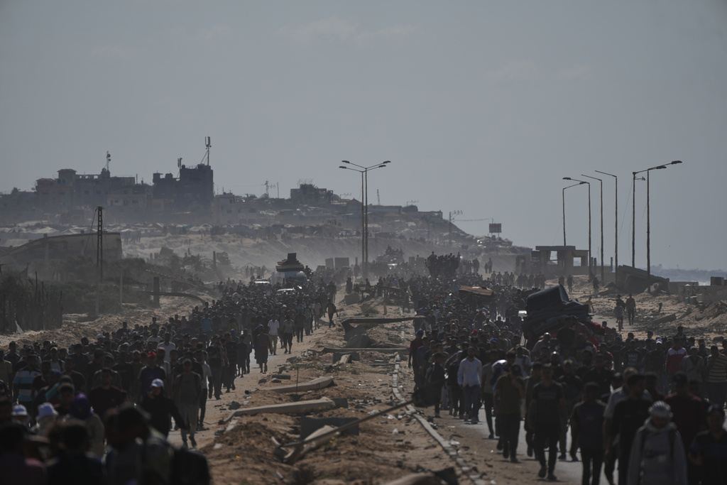 Displaced Palestinians walk with their belongings along the coastal road near Wadi Gaza in the central Gaza Strip, moving toward Gaza City, Friday, Oct. 10, 2025, after Israel and Hamas have agreed to a pause in their war and the release of the remaining hostages. (AP Photo/Abdel Kareem Hana)