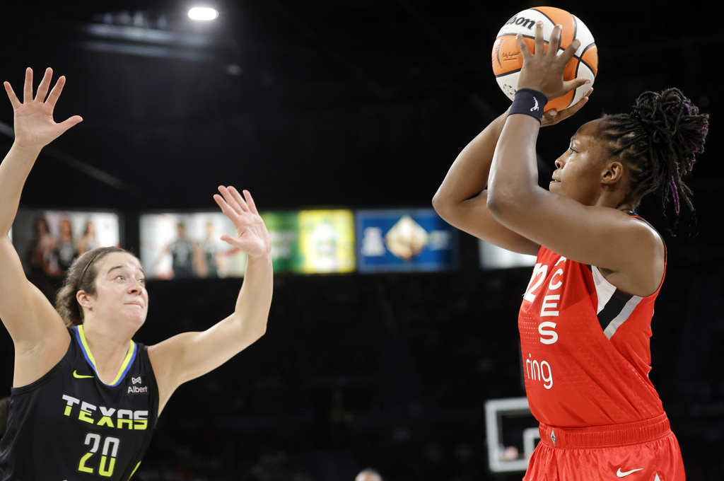 Las Vegas Aces guard Chelsea Gray, right, looks to shoot over Dallas Wings forward Maddy Siegrist (20) during the first half of a WNBA basketball game Sunday, Aug. 17, 2025, in Las Vegas. (Steve Marcus/Las Vegas Sun via AP)