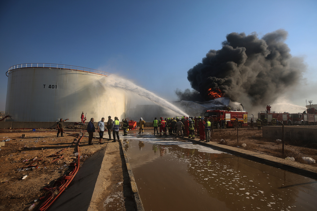 Firefighters work to contain a fire at the Zawiya oil refinery following a drone strike in Zawiya, Libya, Tuesday, Aug. 11, 2026. (AP Photo/Yousef Murad)