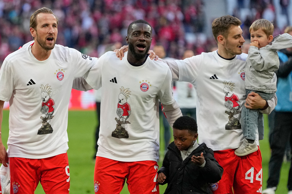 FILE - Bayern's Harry Kane, left, Dayot Upamecano, center, and Josip Stanisic celebrate with their kifds celebrate after their team clinched the German league title after during a Bundesliga soccer match between Bayern and Stuttgart in Munich, Germany, April 19, 2026. (AP Photo/Matthias Schrader, File)