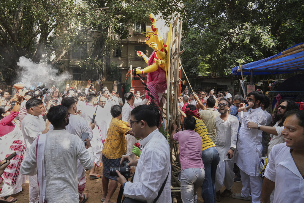 Devotees sing and dance as they prepare to take an idol of the Hindu goddess Durga to their place of worship ahead of the Durga Puja festival in New Delhi, India, Sunday, Sept. 21, 2025. (AP Photo/Manish Swarup)