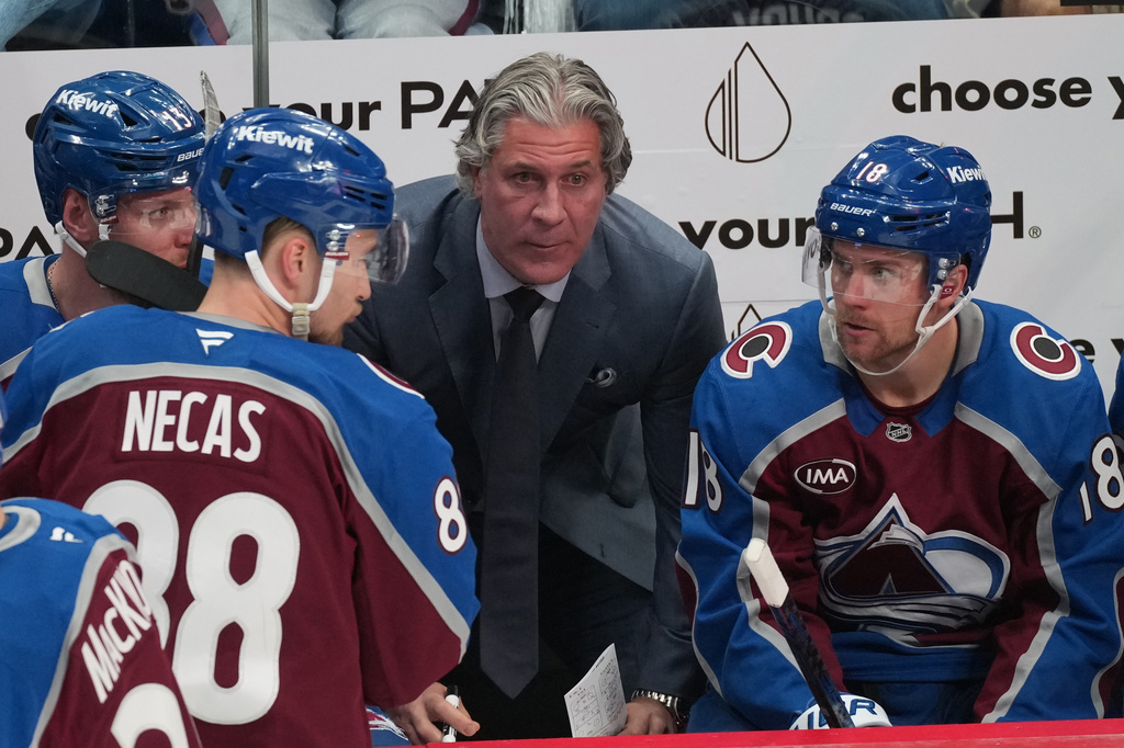Colorado Avalanche head coach Jared Bednar, center, confers with players during a timeout in the third period of Game 1 of an NHL hockey Stanley Cup second-round playoff series against the Minnesota Wild Sunday, May 3, 2026, in Denver. (AP Photo/David Zalubowski)