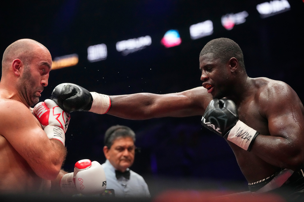 Germany's Peter Kadiru, right, lands a punch on Russia's Murat Gassiev during a WBA Heavyweight world title boxing match as part of the IBA Pro 19 event in Moscow, Russia, Saturday, July. 11, 2026. (AP Photo/Pavel Bednyakov)