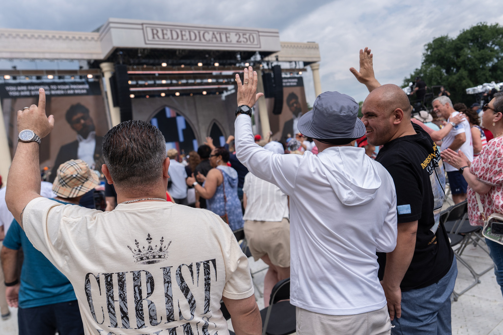 People worship to Christian music at Rededicate 250, a mostly conservative Christian prayer gathering in honor of the United States' 250th anniversary, on the National Mall, Sunday, May 17, 2026, in Washington. (AP Photo/Julia Demaree Nikhinson)