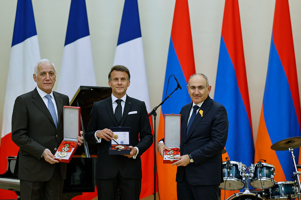 In this photo distributed by the Armenian Prime Minister Press Office, Armenian President Vahagn Khachaturyan, left, French President Emmanuel Macron, center, and Armenian Prime Minister Nikol Pashinyan hold awards following a state dinner after the European Political Community in Yerevan, Armenia, Monday, May 4, 2026. (Tigran Mehrabyan/Armenian Prime Minister Press Office via AP)