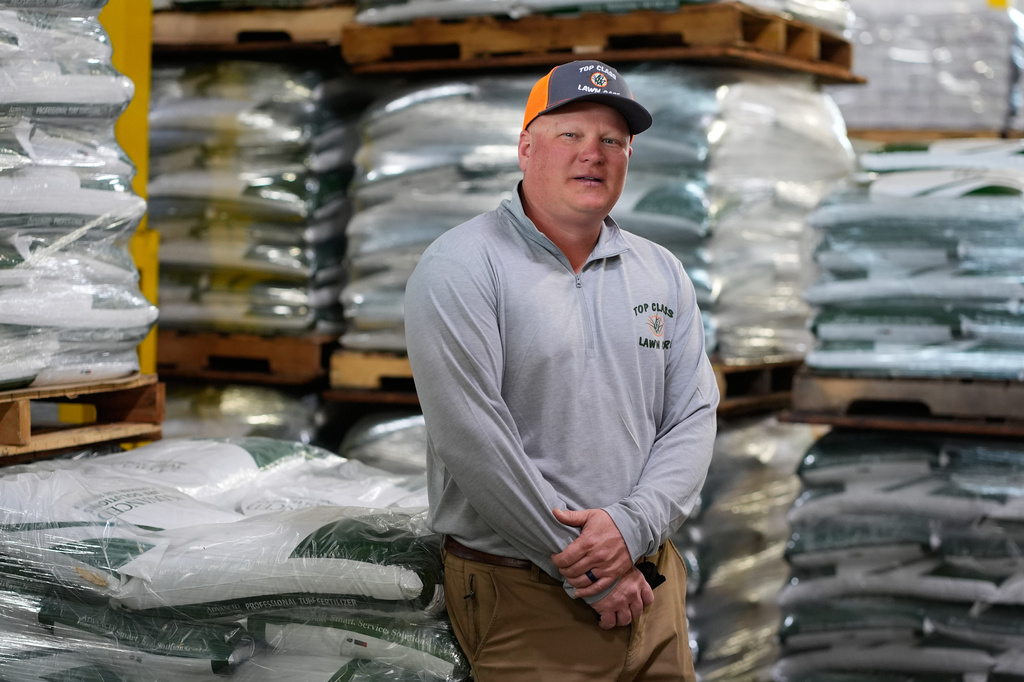 Top Class Lawn Care owner Jake Wilson stands by fertilizer he stockpiled at his supplier's warehouse in anticipation of Iran war related price hikes Thursday, March 26, 2026, in Riverside, Mo. (AP Photo/Charlie Riedel)