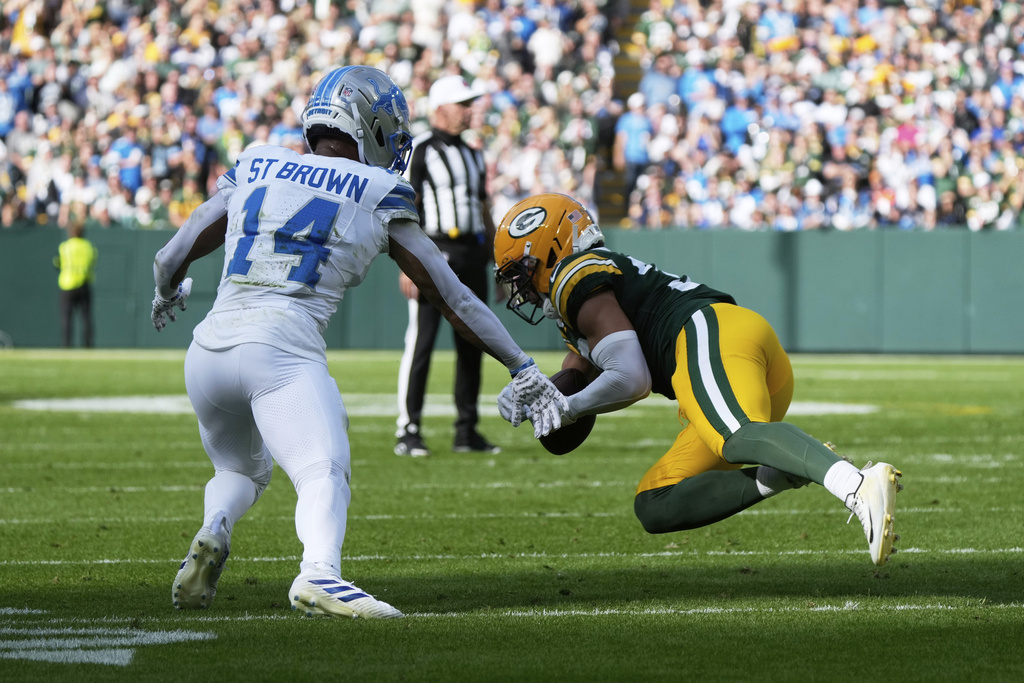 Green Bay Packers safety Evan Williams (33) intercepts a pass intended for Detroit Lions wide receiver Amon-Ra St. Brown (14) during the first half of an NFL football game Sunday, Sept. 7, 2025, in Green Bay, Wis. (AP Photo/Morry Gash)